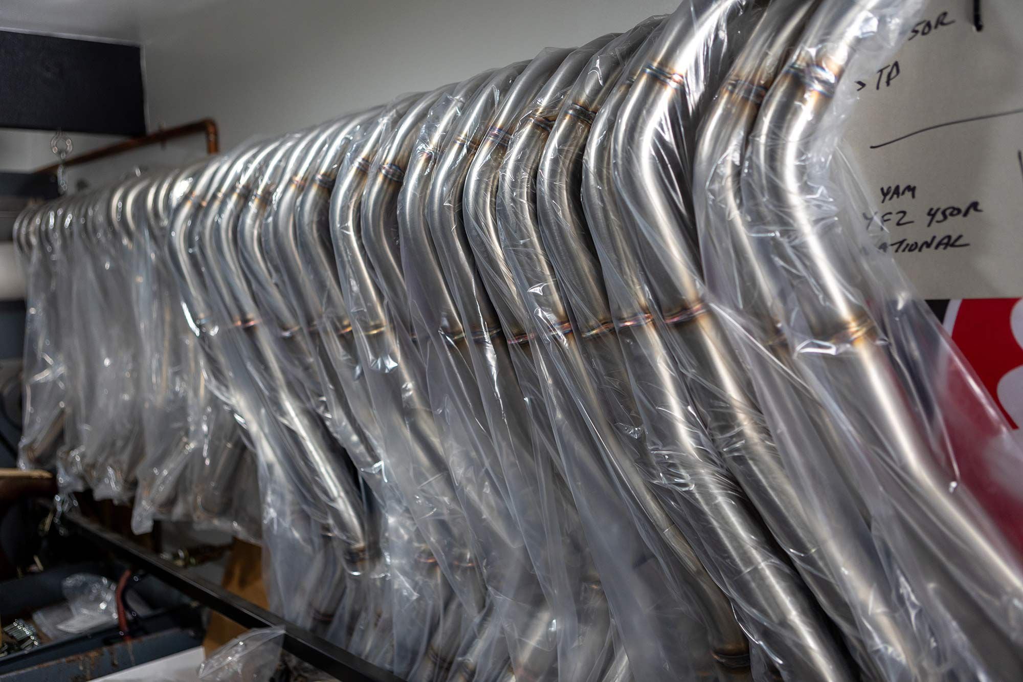 A row of four-stroke exhaust systems are ready for shipping.